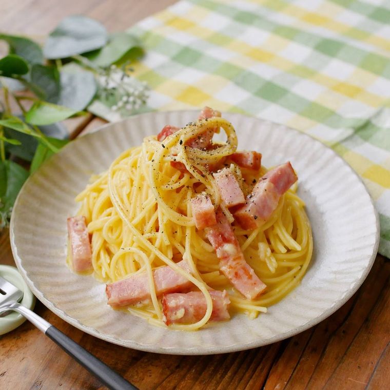 白い皿に盛りつけられた牛乳で作るカルボナーラ