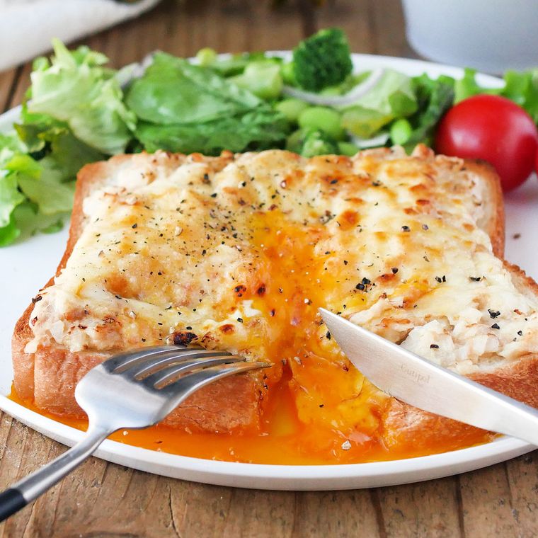 白い皿の上でツナたまトーストを切っている様子