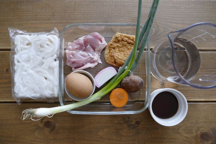鍋焼きうどんの材料が並ぶ木製テーブル