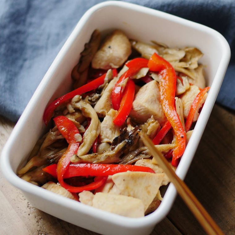 白い保存容器に入れた鶏むね肉と舞茸のコンソメバター炒め