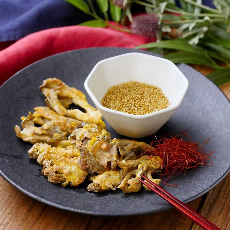 黒いまるい皿にのせた舞茸チヂミ