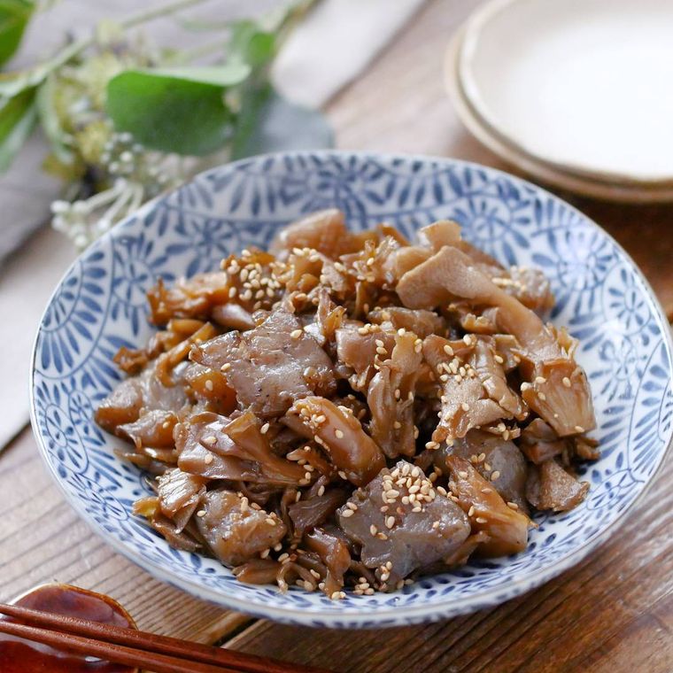 青い模様の皿にのせた舞茸とこんにゃくの甘辛煮