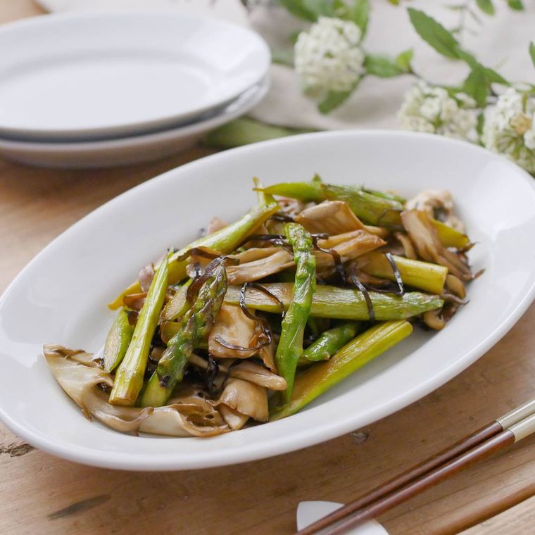 白いオーバル皿にのせた舞茸とアスパラガスの塩こんぶバター炒め