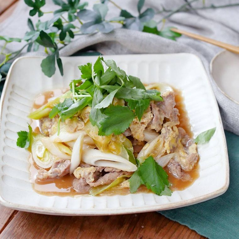 白の四角い皿に盛り付けた長ねぎと豚こま肉の卵とじ