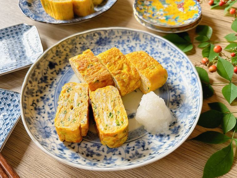 青と白の皿に盛られたネギたっぷりのだし巻き卵