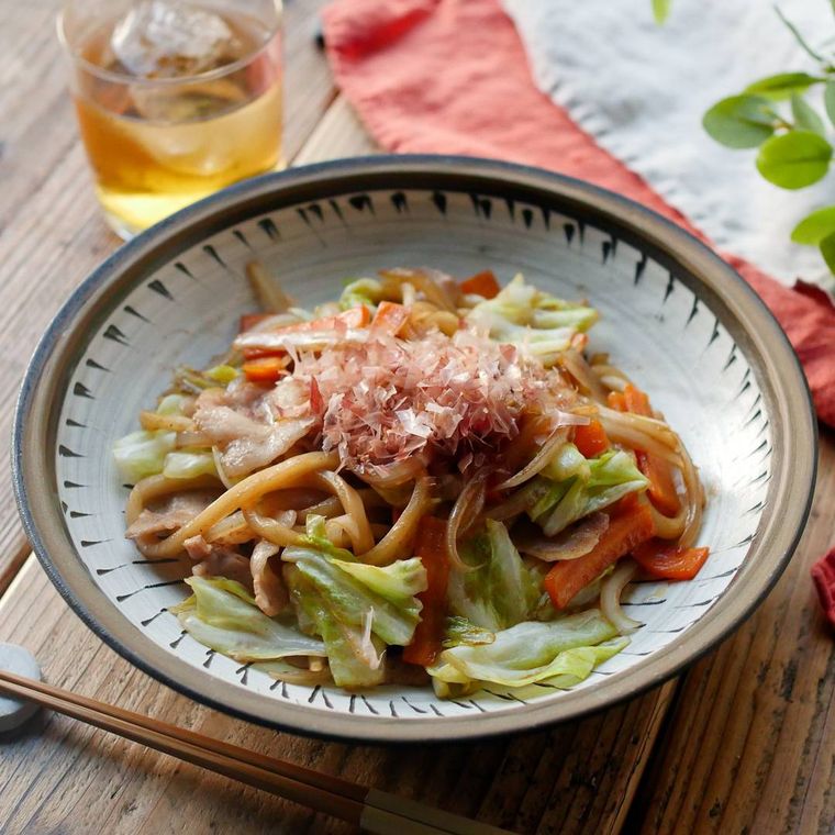 器に盛りつけられたソース焼きうどんに麦茶が添えられている