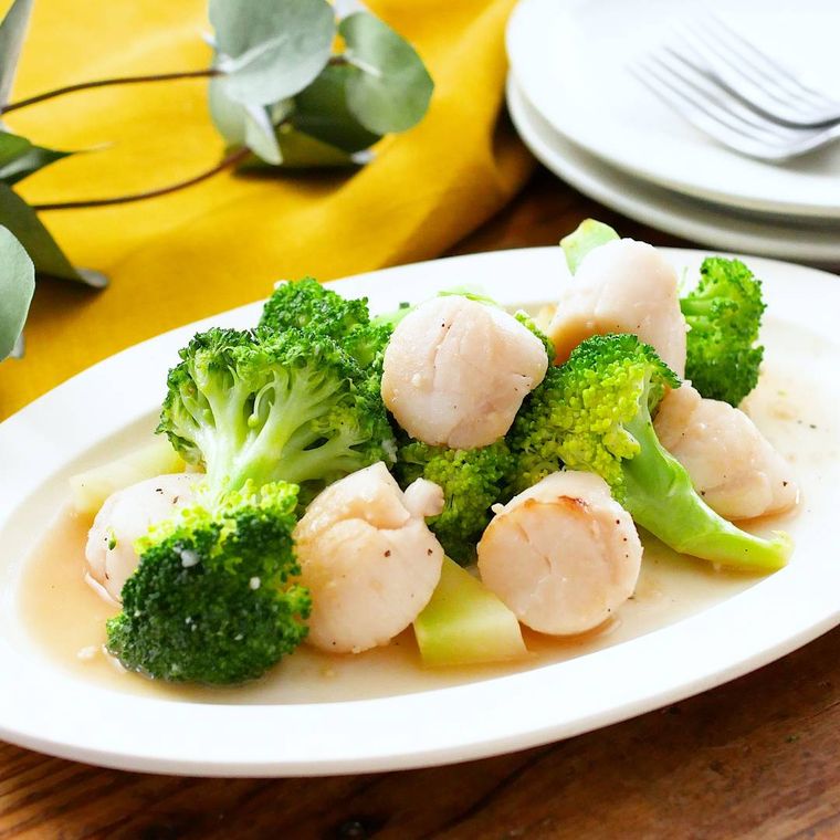 白い皿に盛りつけられた貝柱とブロッコリーのガーリック炒め