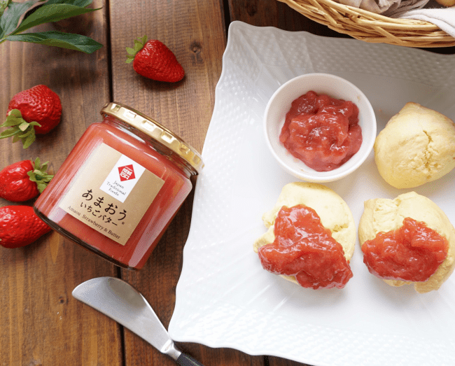 テーブルに白いお皿と成城石井のあまおういちごバターが置かれている