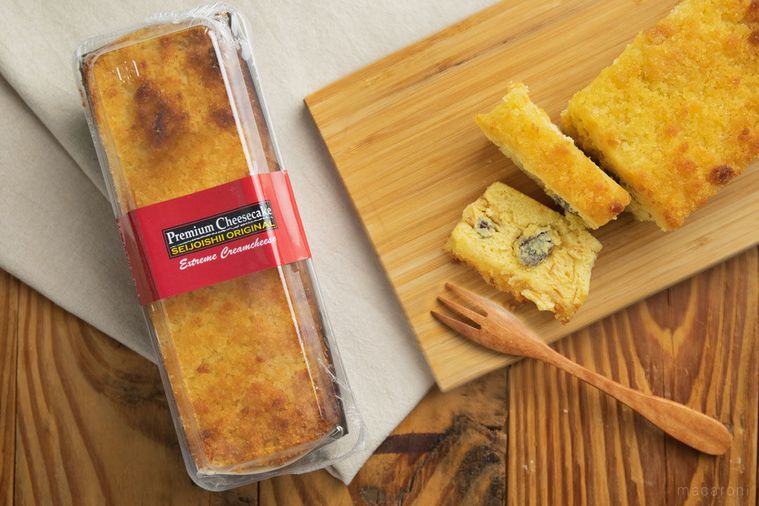 テーブルの上に置かれたまな板とフォークと成城石井のプレミアムチーズケーキ
