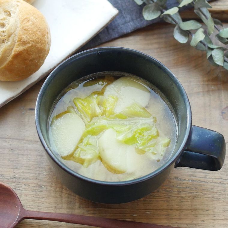 黒いスープカップに注がれた、春キャベツと新じゃがのみそバタースープ