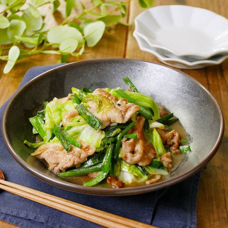 黒い丸皿に盛り付けられたニラ豚キャベツ