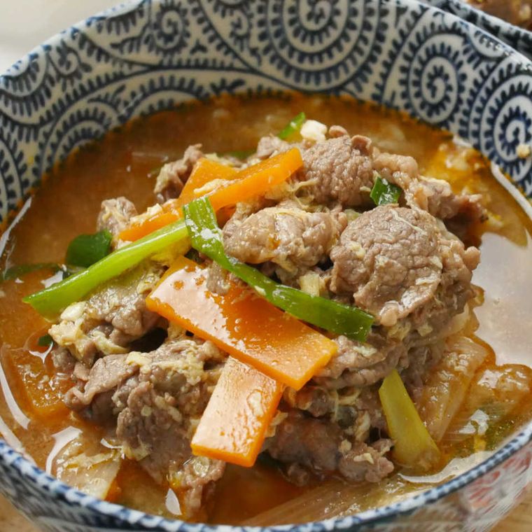 青と白のお茶碗に盛られた牛こま肉とニラのピリ辛クッパ