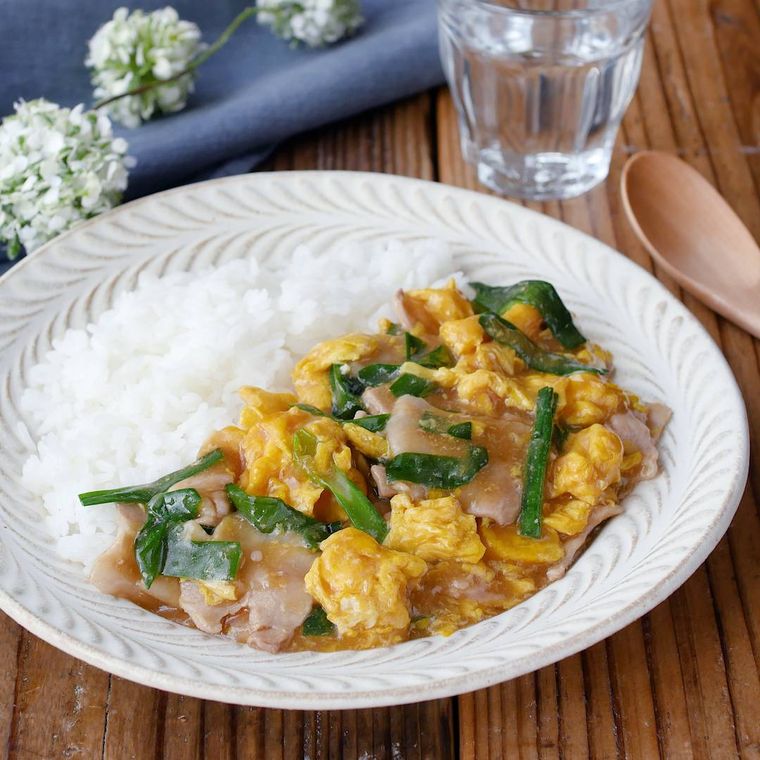 白い丸皿に盛られた豚肉とニラのとろたまあんかけごはん