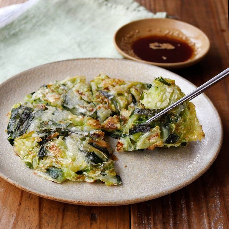 丸いお皿に盛り付けられたキャベツとニラのチヂミ