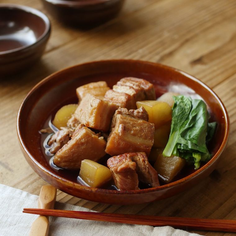 茶色い丸いお皿に盛られた豚の角煮