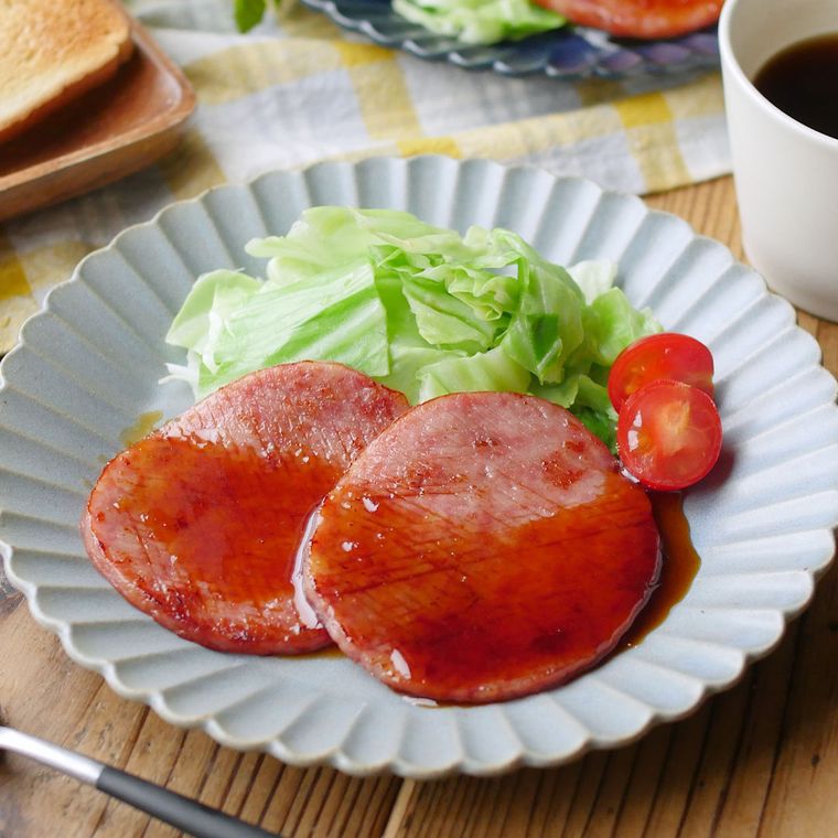 花びら形の皿に盛りつけられた、ハムステーキと野菜のつけ合わせ