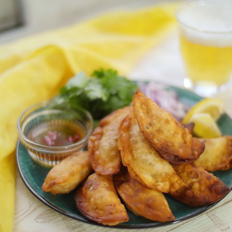 緑色の皿に盛り付けられた、ガパオ揚げ餃子