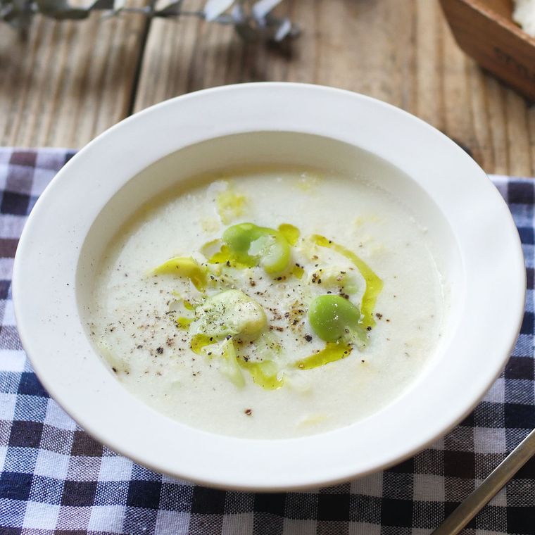 白い皿に盛り付けられたそら豆とキャベツのふわとろポタージュ