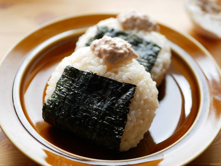 茶色い皿にコンビニ風和風ツナマヨおにぎりが2個のっている様子