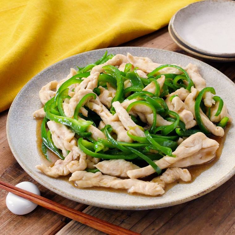 細切りの鶏むね肉とピーマンの炒め物が盛られている白い皿