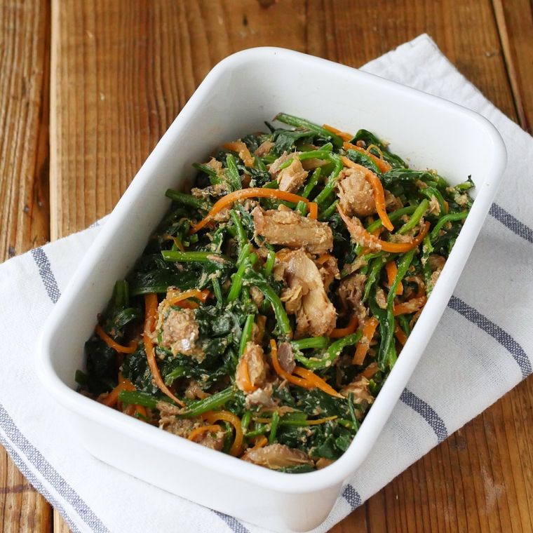 白い保存容器に入ったほうれん草とさば味噌煮缶のごま和え