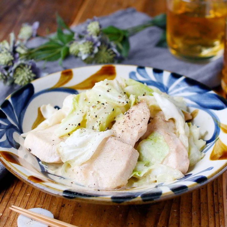 和柄の皿に盛り付けられている鶏胸肉とキャベツのマヨポン炒め