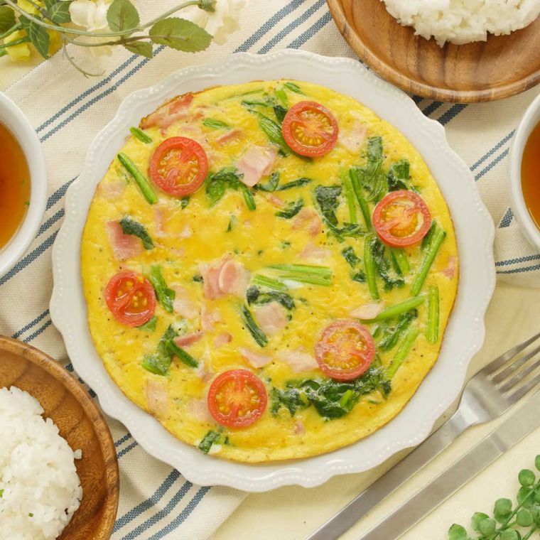 お皿に盛られたオープンオムレツとご飯が並んだ食卓