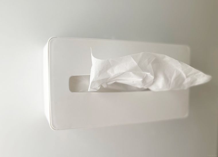 壁にマグネットテープでティッシュケースを固定している