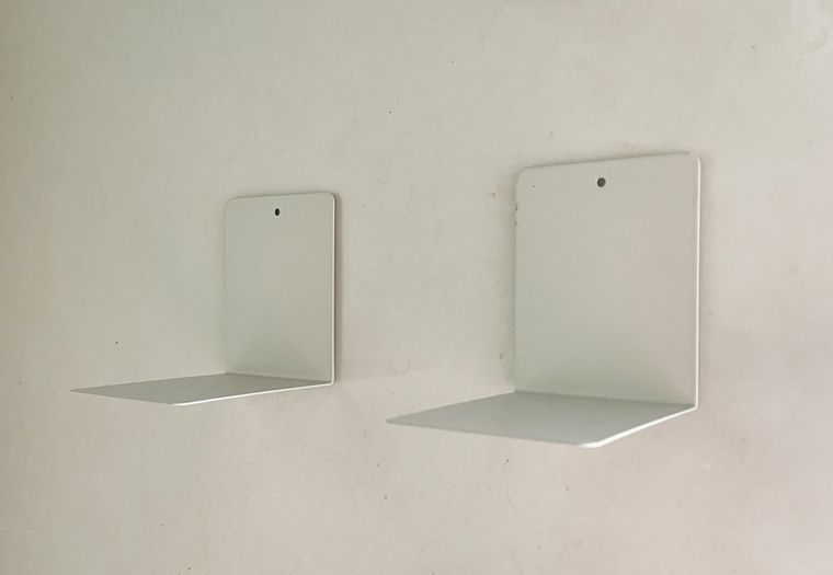 マグネットテープで壁にブックエンドを固定している