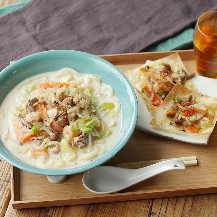 ターコイズブルーの器に盛り付け、れんげを添えたちゃんぽんうどん