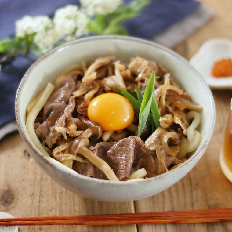 器に盛り付け中心に卵黄をトッピングした牛すきうどん