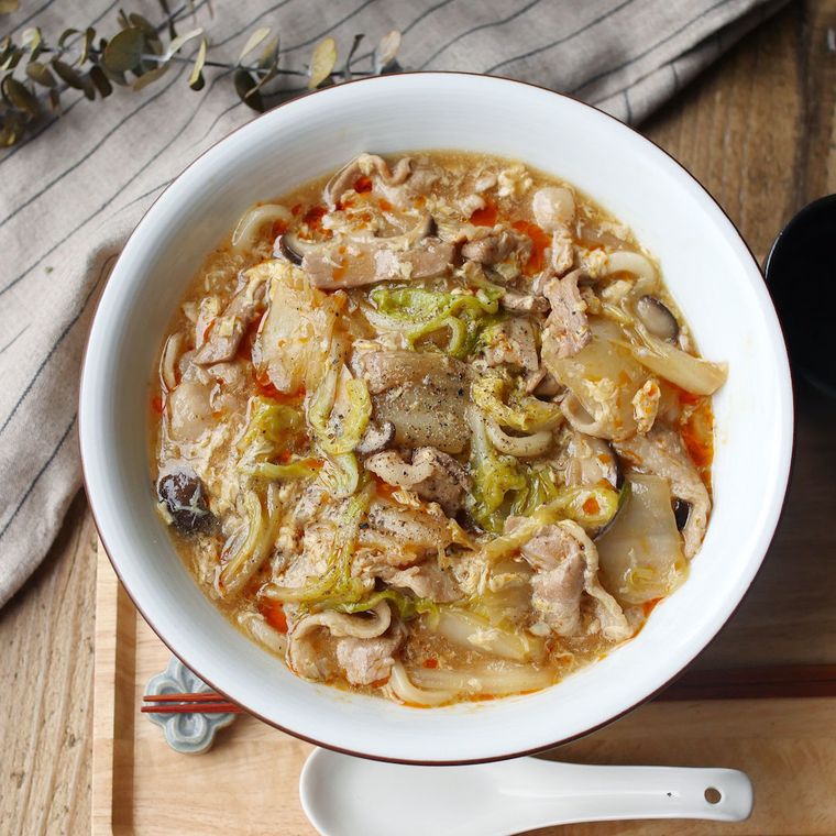 白い器に盛り付け、れんげを添えたあんかけ卵とじうどん