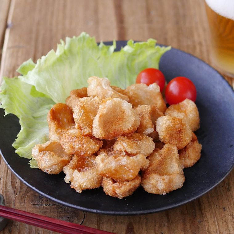 黒い皿に付け合わせの野菜と一緒に盛られた、麩の唐揚げ