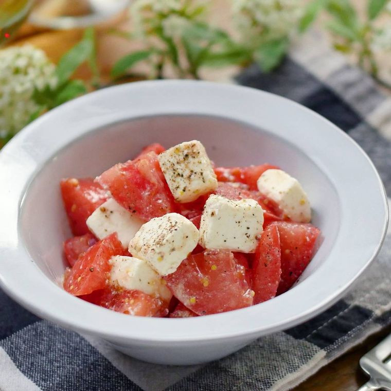 白い皿に盛られたトマトとチーズの粒マスタードサラダ