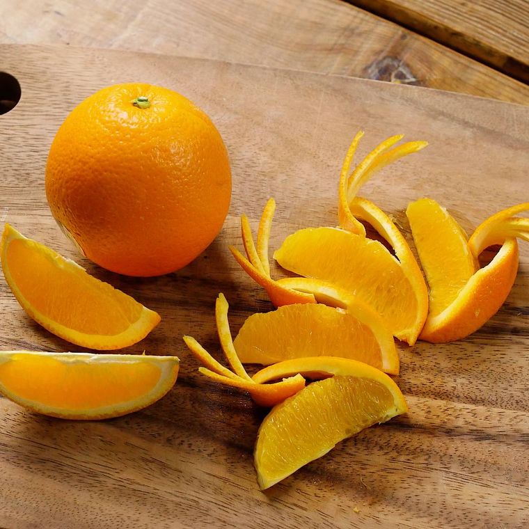 まな板でくし形切りと羽がついたように飾り切りされたオレンジ