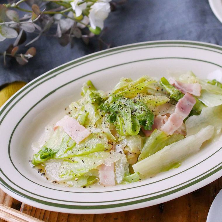 緑の縁どりの皿に入ったレタスとベーコンのうま塩炒め