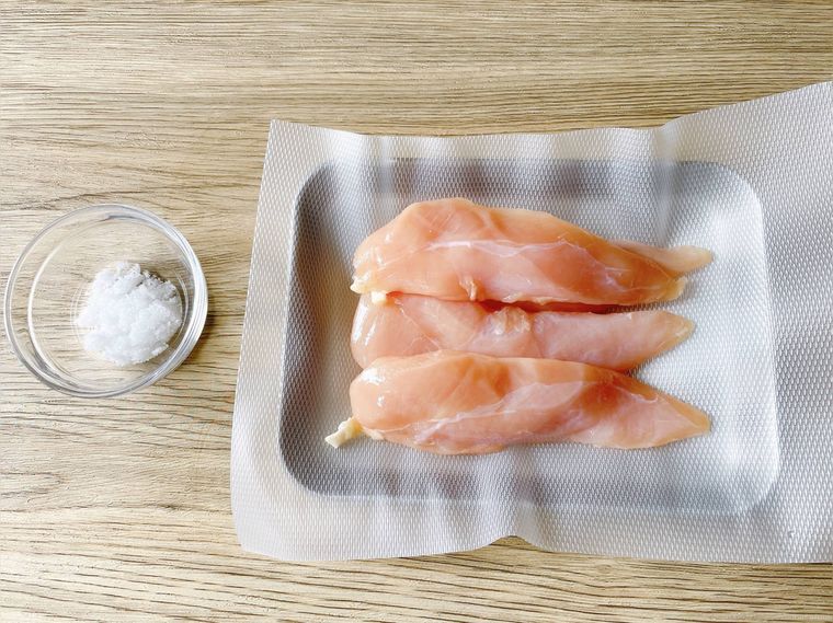 テーブルに置いたバットにのせた鶏ささみ、塩