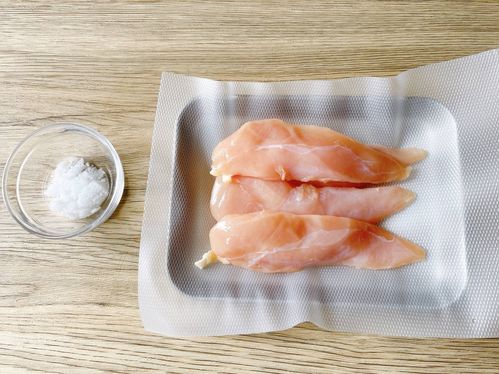 テーブルに置いたバットにのせた鶏ささみ、塩