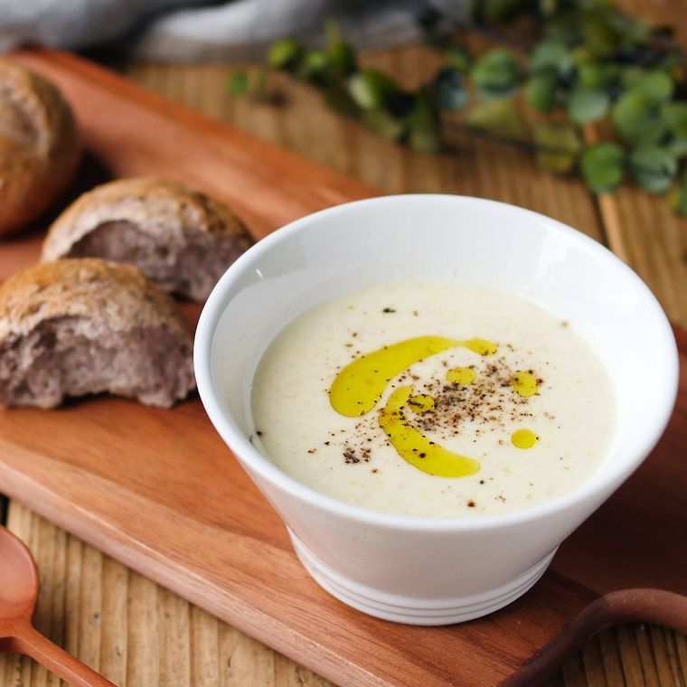 白い茶碗に盛りつけられたネギとベーコンのポタージュ