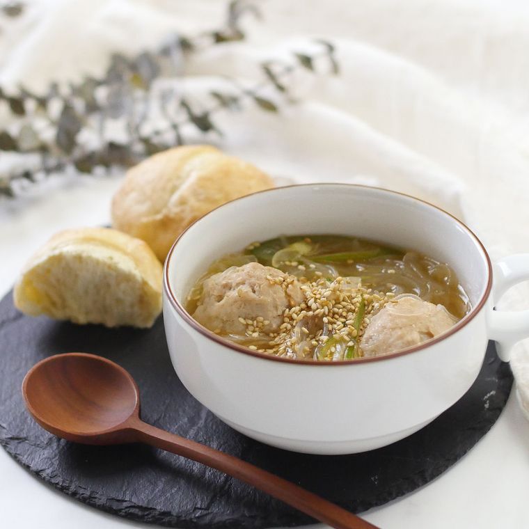 白い片手のスープ皿に盛りつけられた鶏団子のたっぷりネギごまスープ