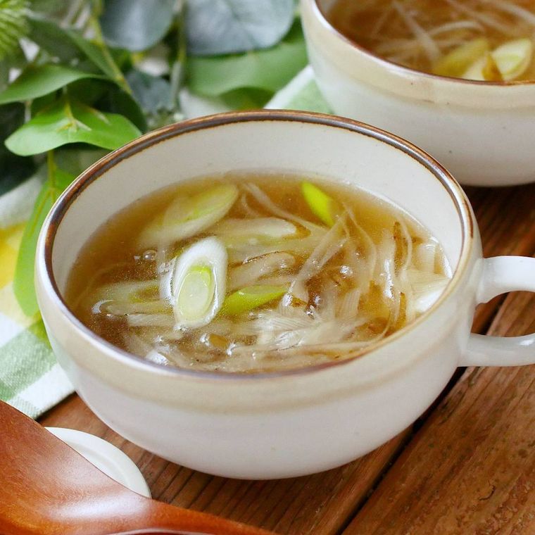 白いマグカップに盛りつけられたごぼうとネギの和風スープ