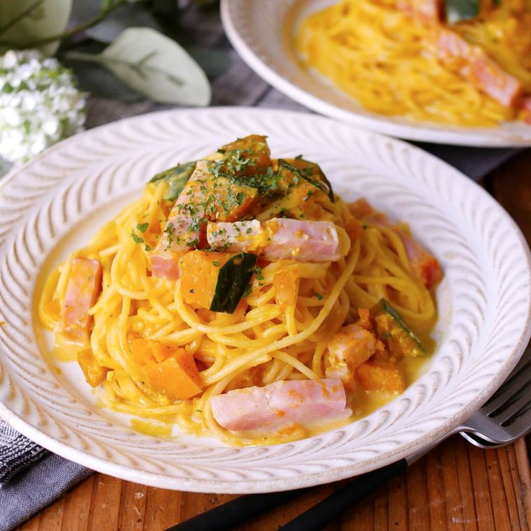 白い皿に盛り付けられているかぼちゃのクリームパスタ