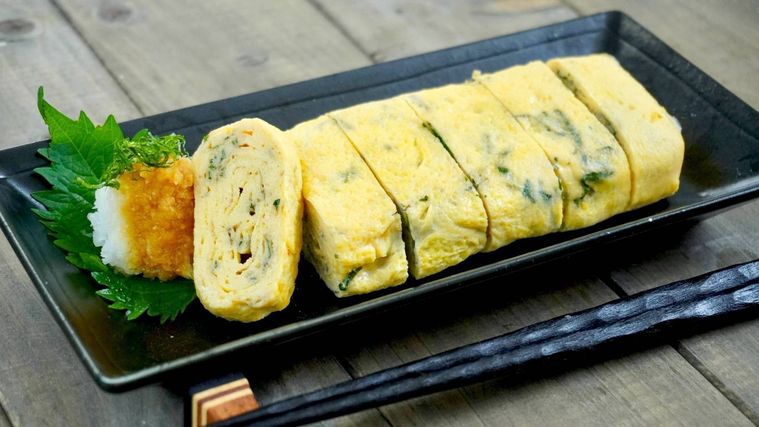 黒い皿に盛られた、青じそのふんわり卵焼き