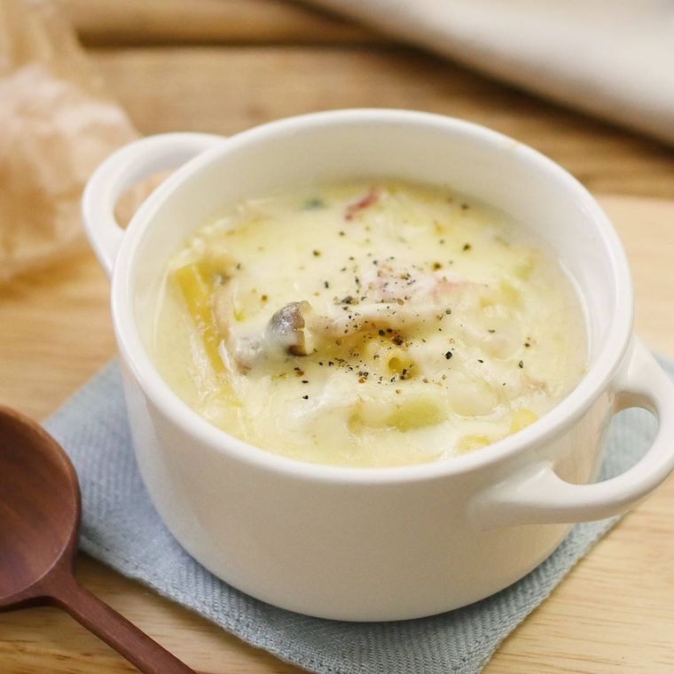 手付きの白いカップに入った、豆乳のマカロニグラタンスープ