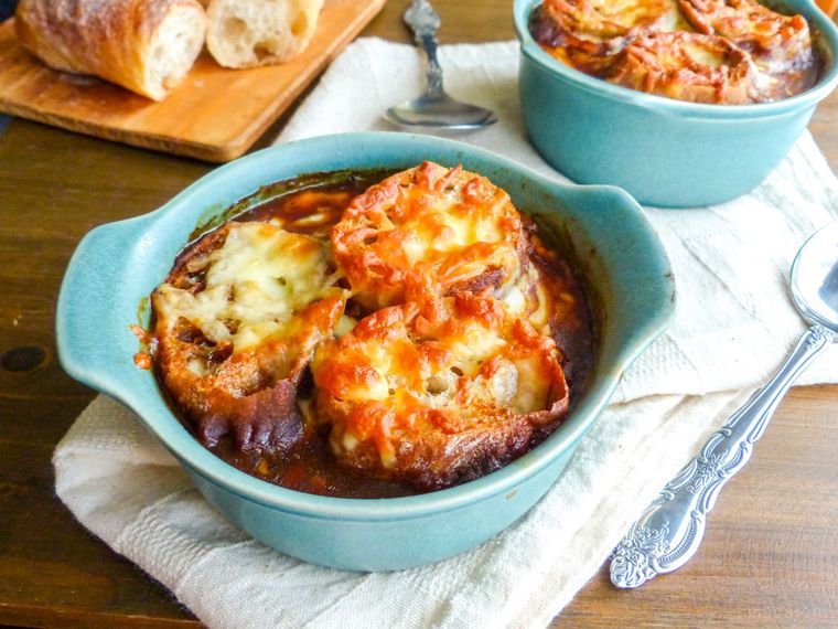 水色の器に入ったオニオングラタンスープがある食卓