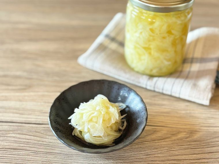 保存瓶から黒い皿に取り出した穀物酢で作る酢玉ねぎ