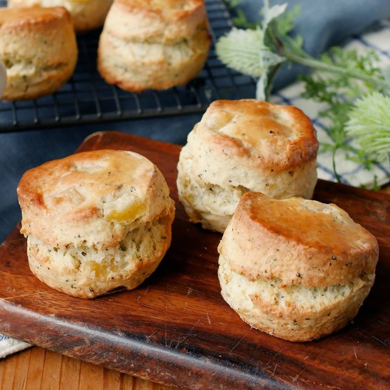 木製のボードに並べた紅茶とりんごのスコーン