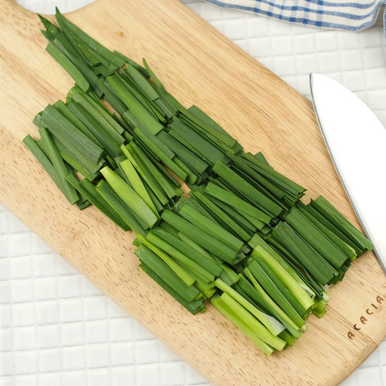 木のまな板にのったニラ