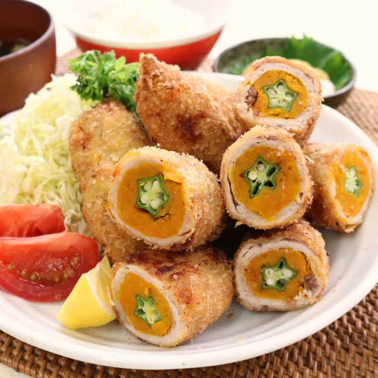 白いお皿に盛られた、かぼちゃのサクサク豚肉巻きフライ、トマト、キャベツ、レモン