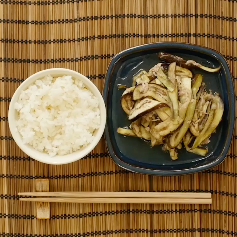 テーブルの上に置かれたごはんと無限なす